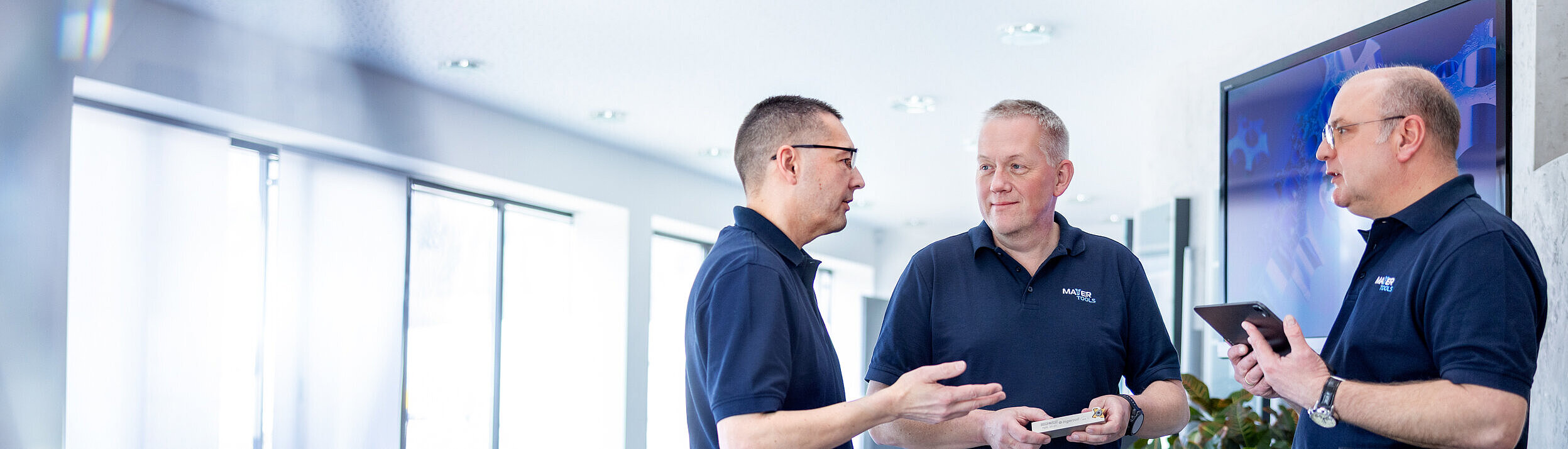 Drei technische Berater unterhalten sich in einem Besprechungsraum