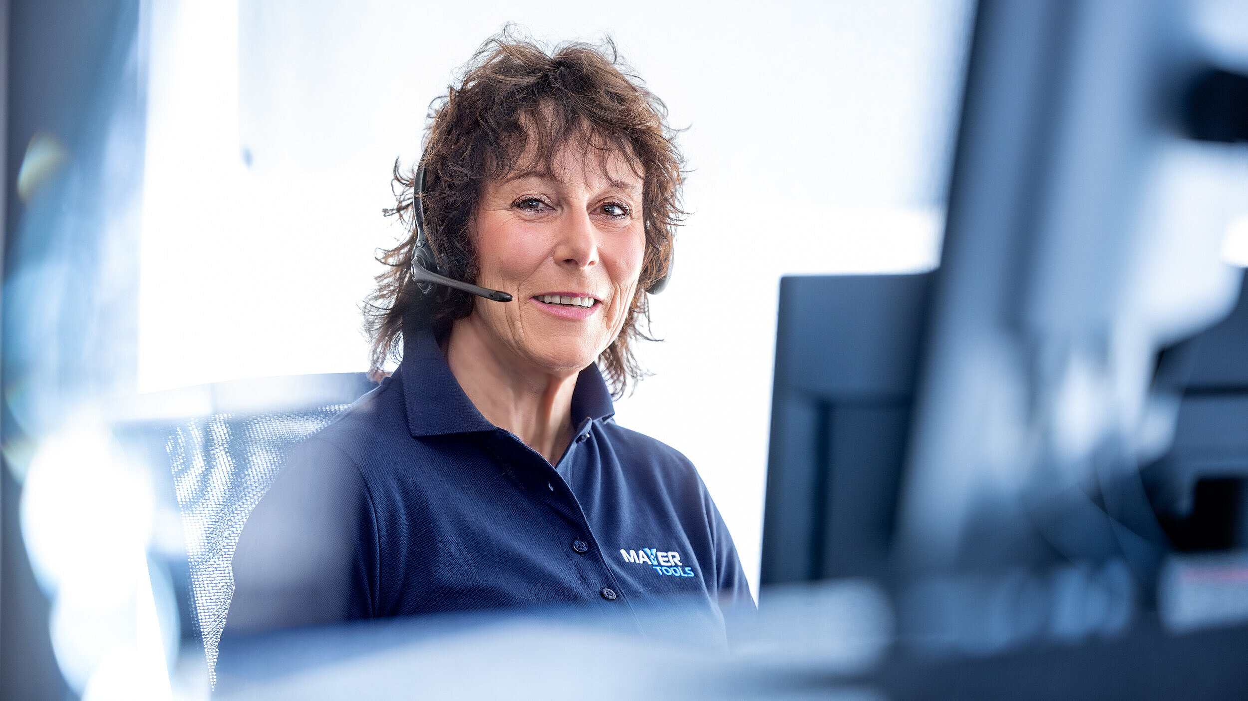 Eine Frau mit Headset am Computer